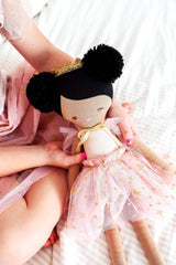 Soft fabric princess doll with ebony yarn hair styled in two buns, wearing a blush pink tulle dress with gold star accents.