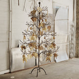 Jan Barboglio Mesquite iron tree with gold ornaments in a studio