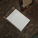 Jan Barboglio Apuntes iron notepad on a dark wood desk, from above